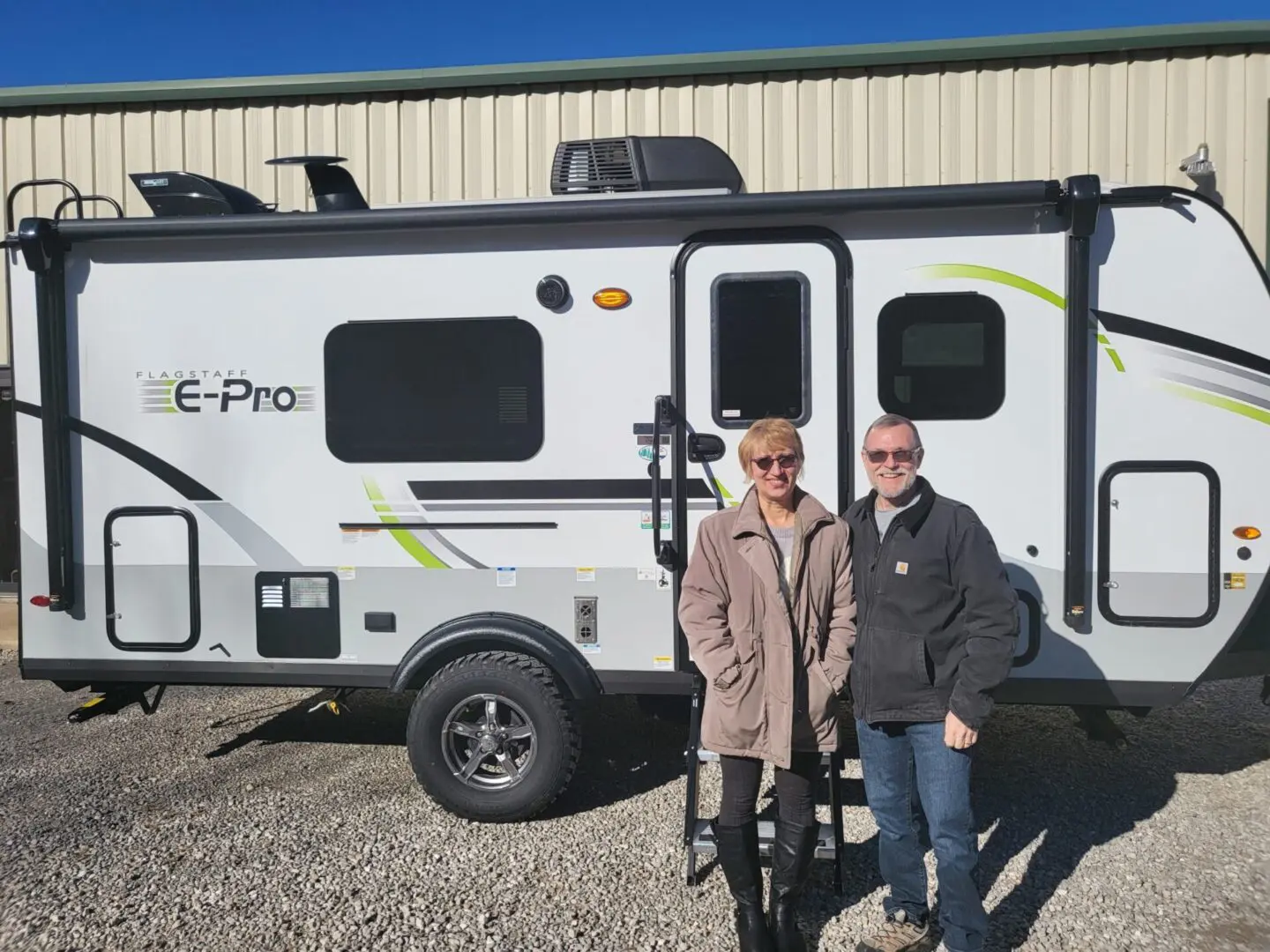 People posing next to a camper