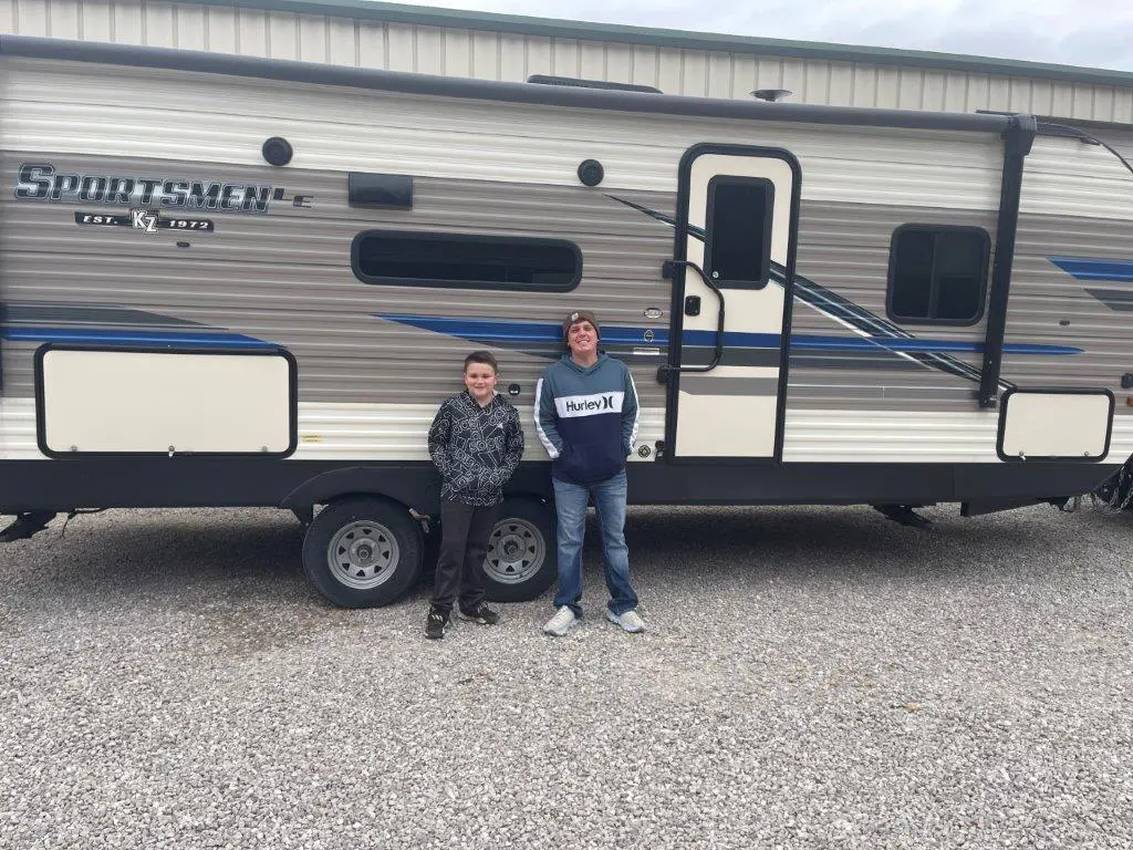 Family posing next to RV