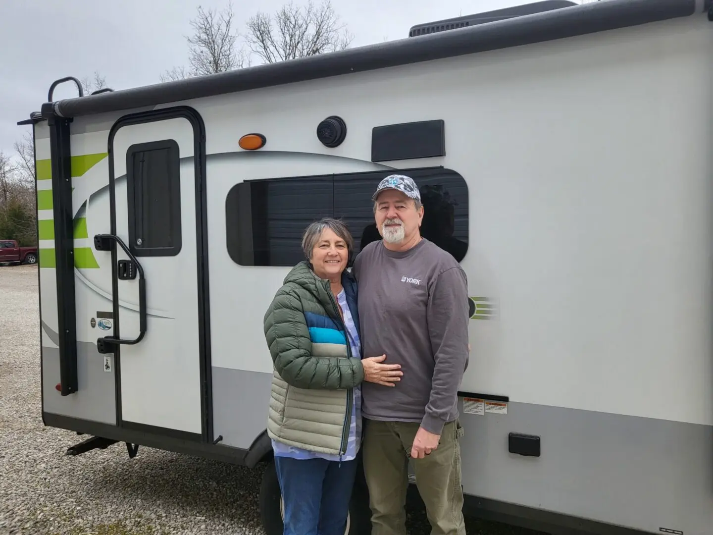 Couple standing by a travel trailer