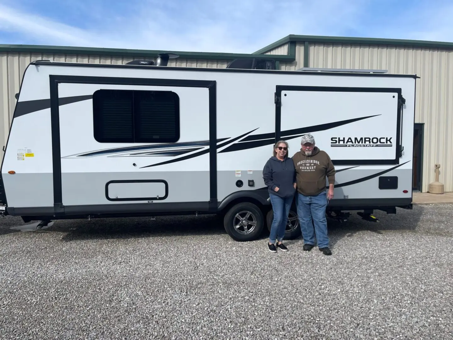 Couple standing by a travel trailer