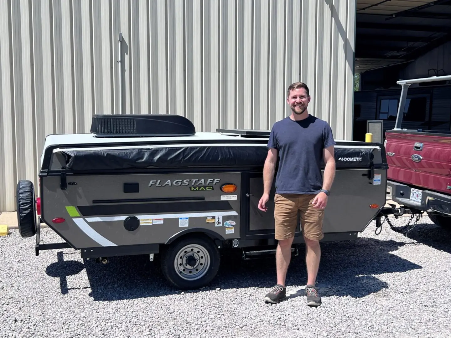 Person beside a compact travel trailer
