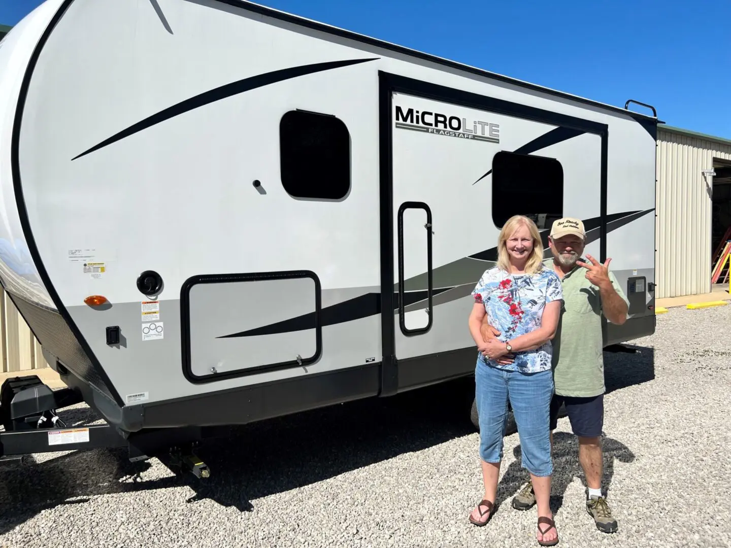 Couple standing by their travel trailer