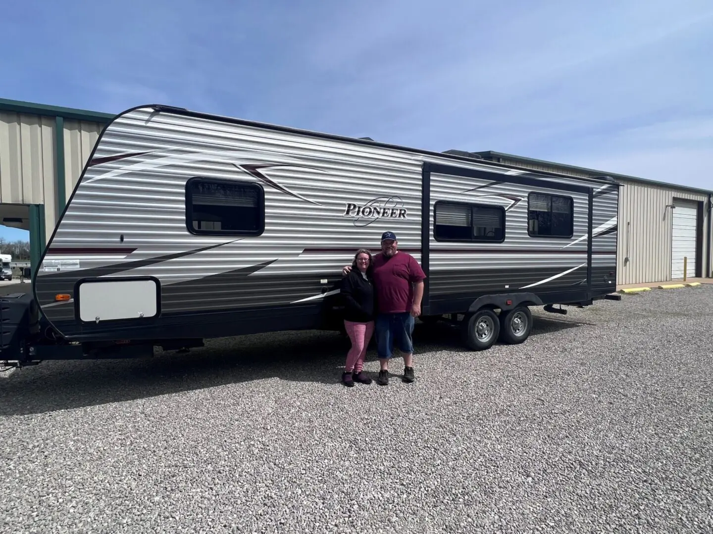 People posing with a travel trailer