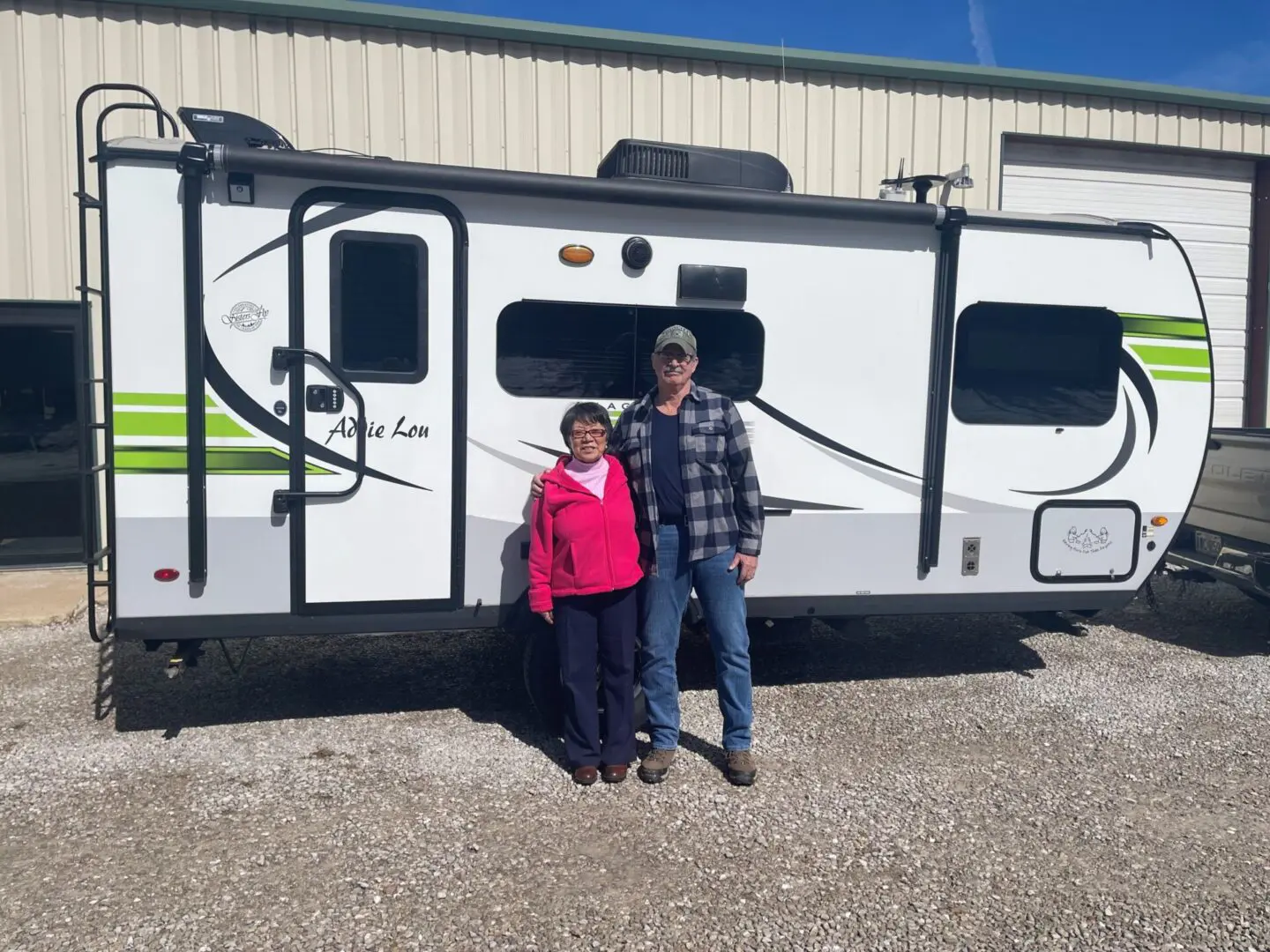 Couple standing in front of camper