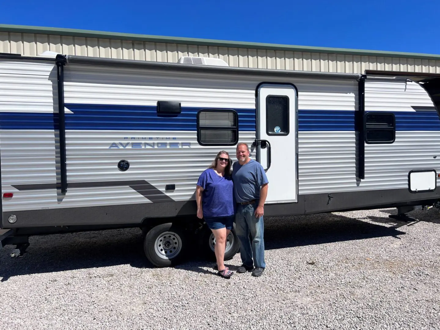 Pair smiling beside their RV