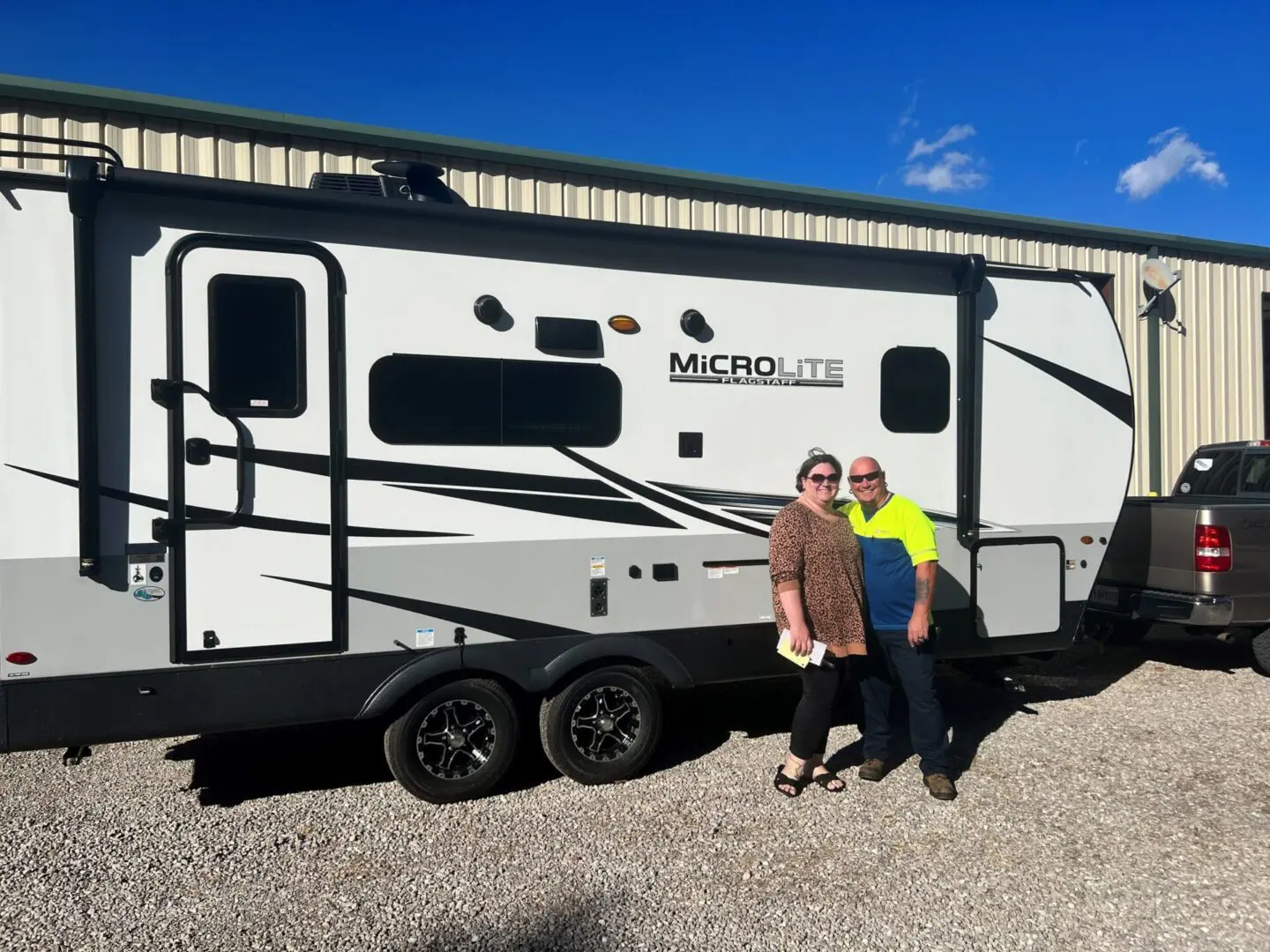 Couple standing by a travel trailer