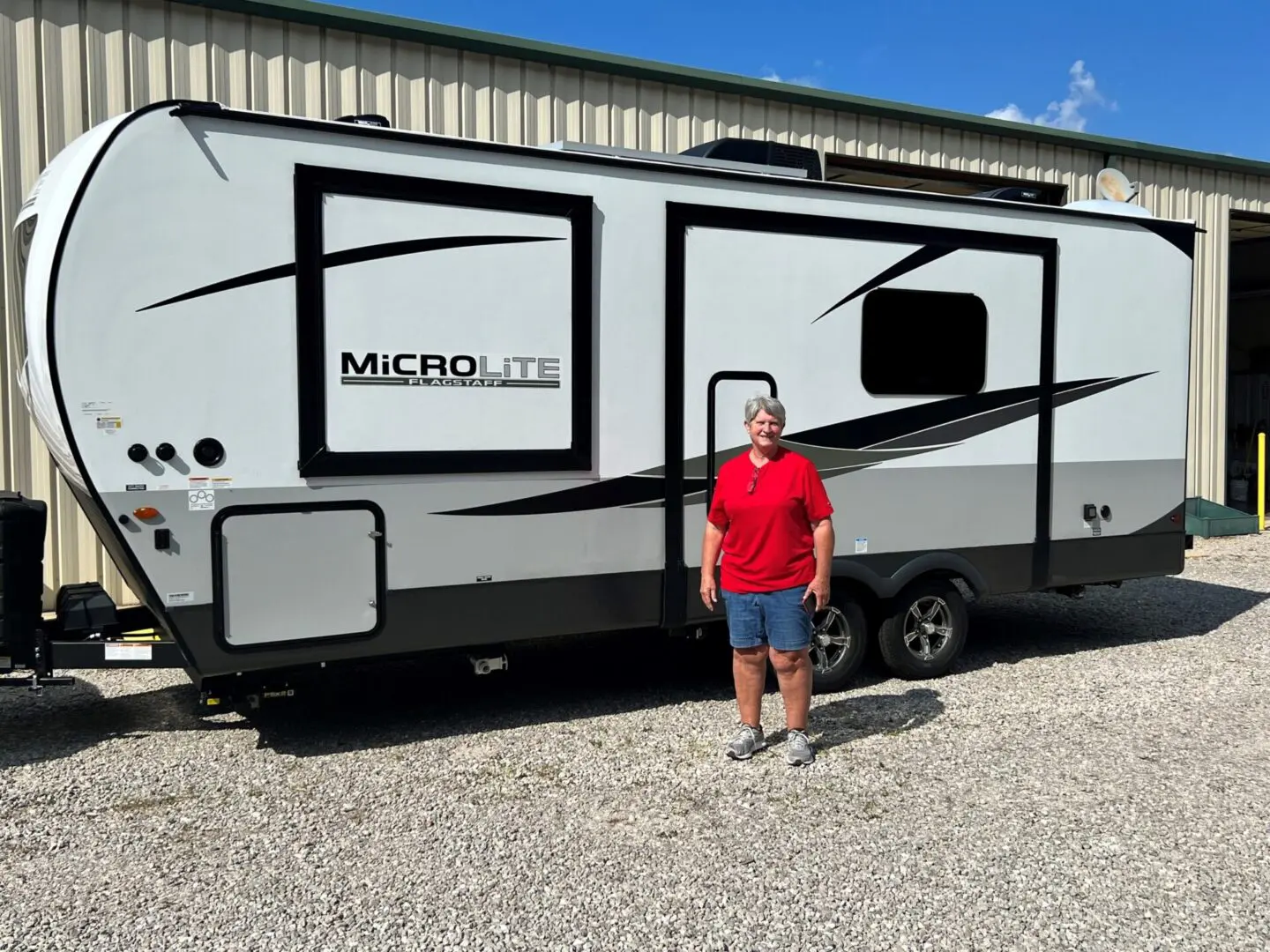 White and black camper with person nearby