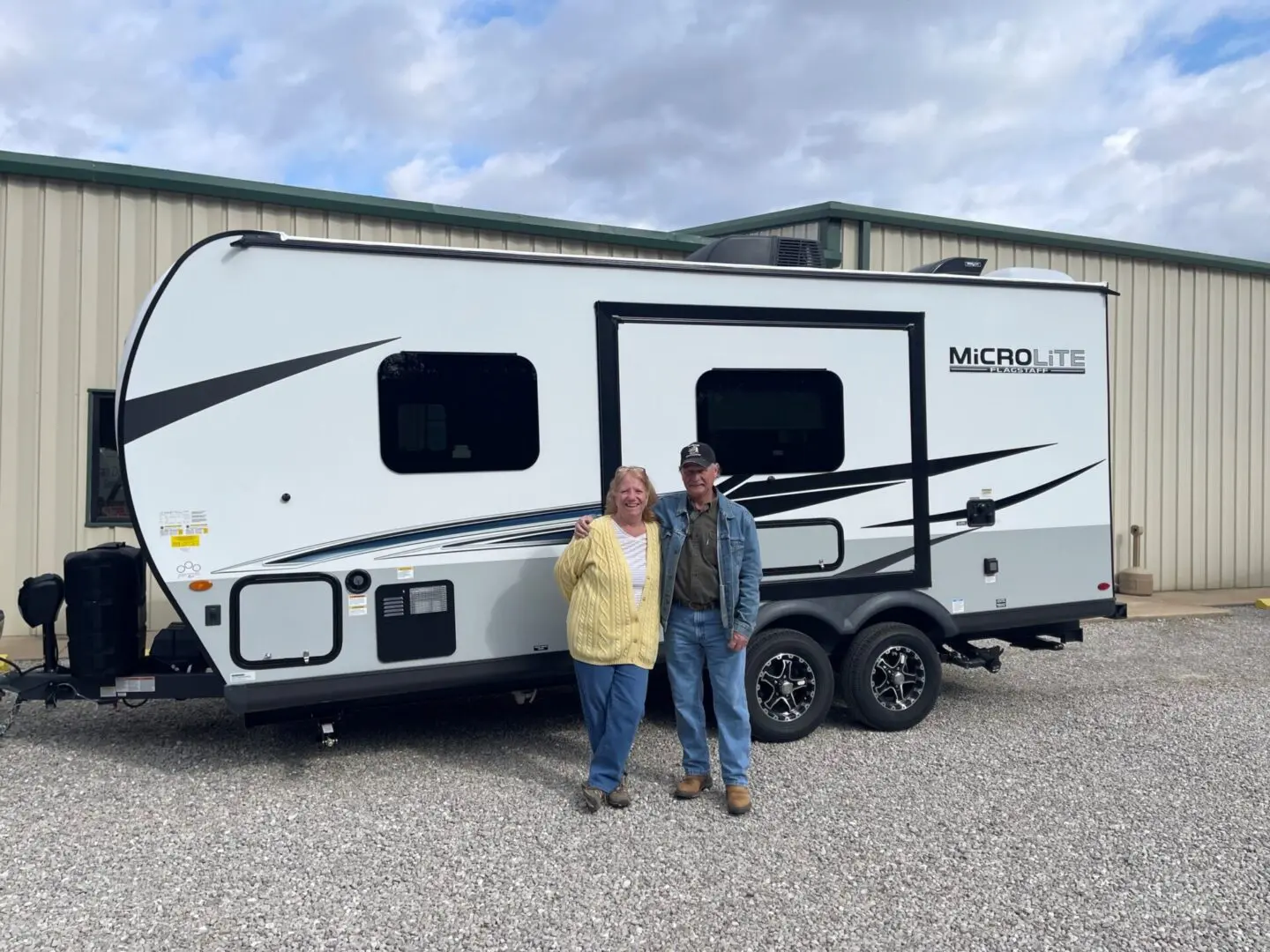 Two people beside a Micro Lite trailer
