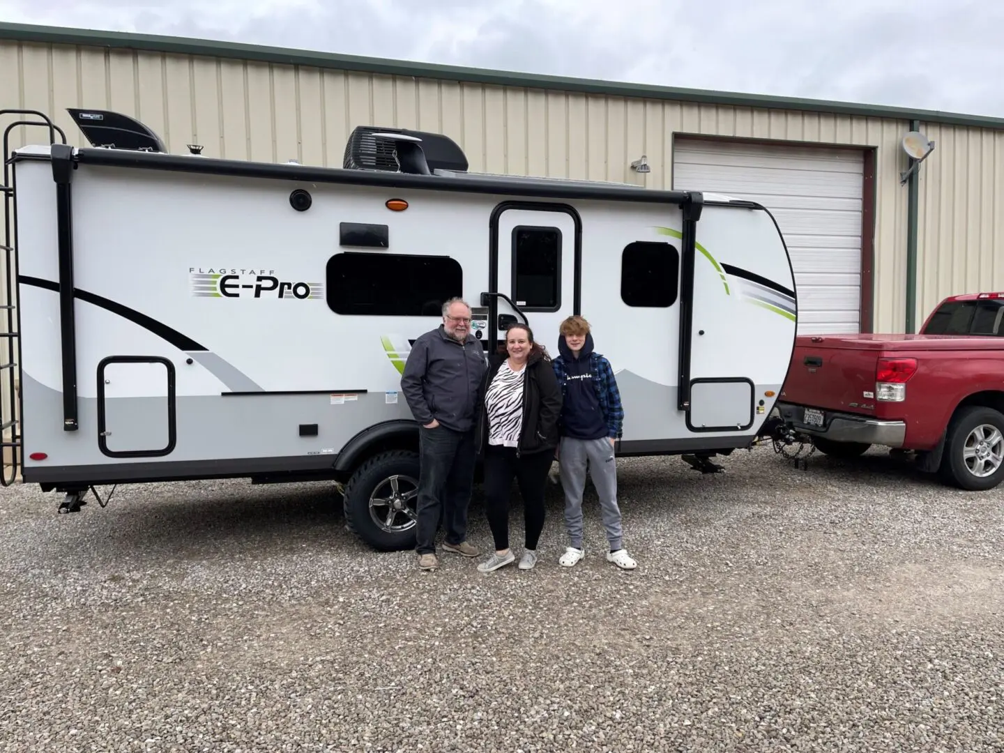 Family posing with travel trailer